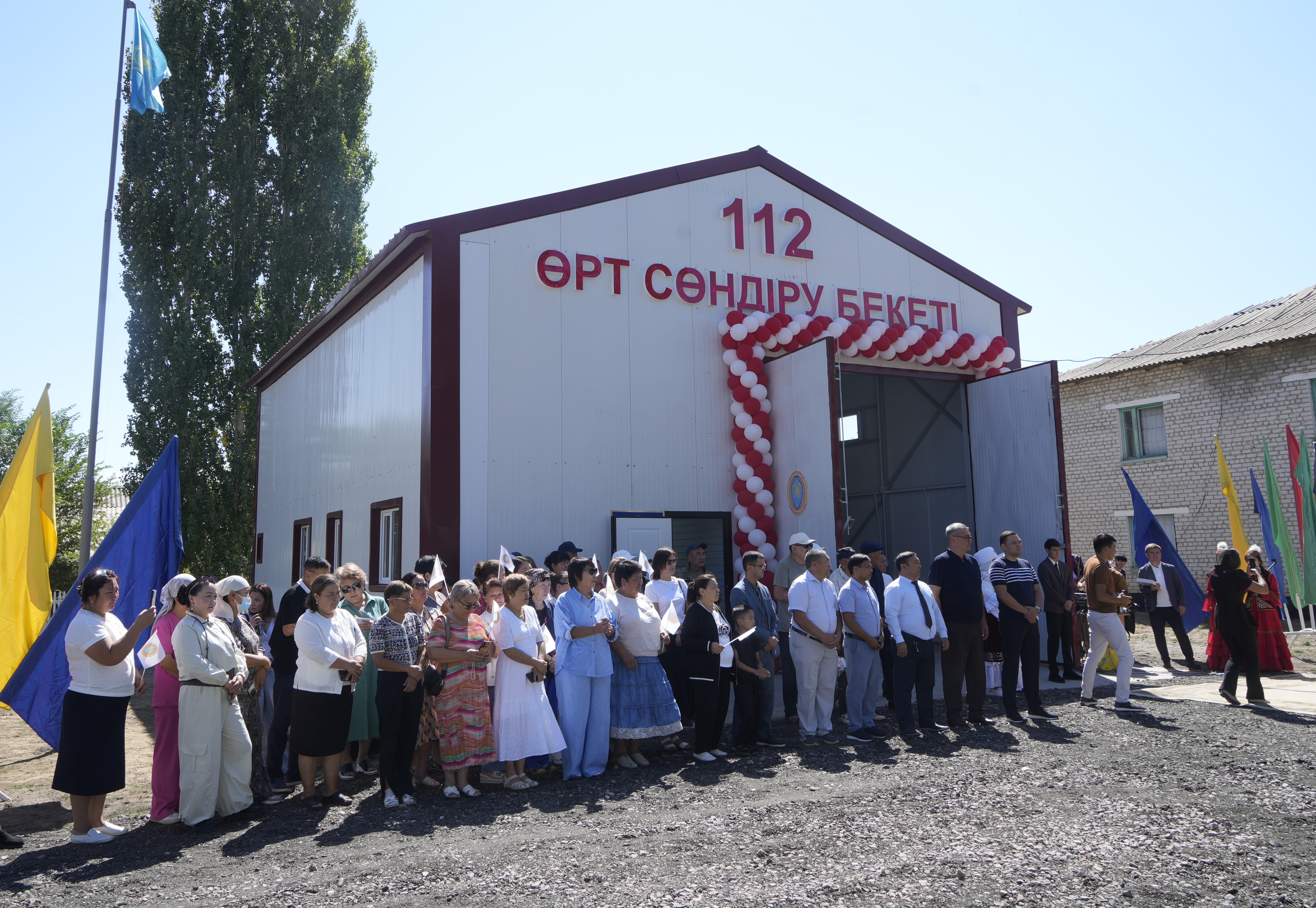 «112 Өрт сөндіру бекеті» ғимаратының алдында жиналған адамдар тобы.