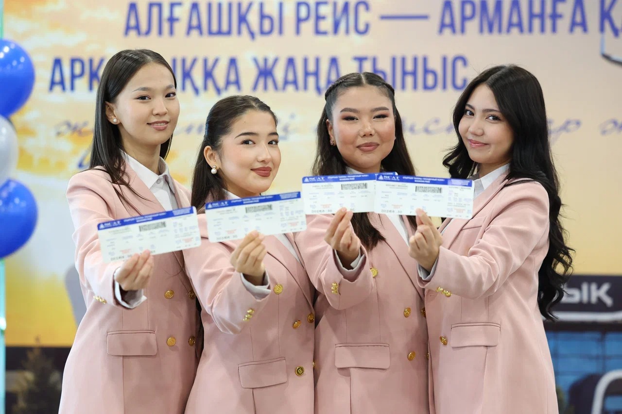 Авиакомпания өкілдері бірінші рейстің символдық билеттерін көрсетеді