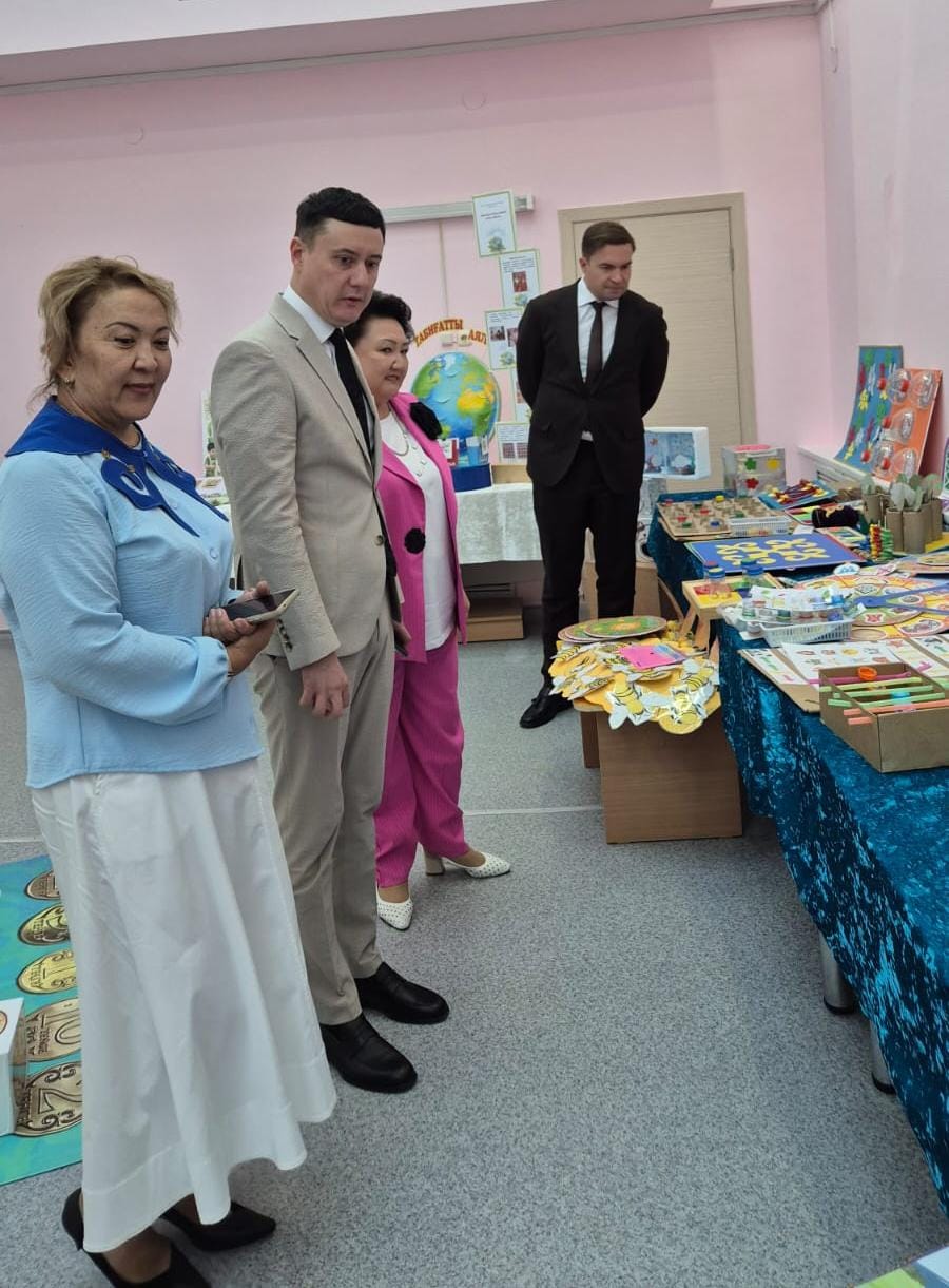 Мектептегі шығармашылық жұмыстар көрмесін тамашалап тұрған комиссия мүшелері.