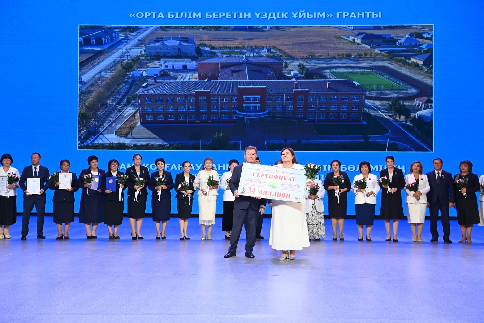 «Орта білім беретін үздік ұйым» грантын жеңімпаздарының сахнадағы ортақ суреті.