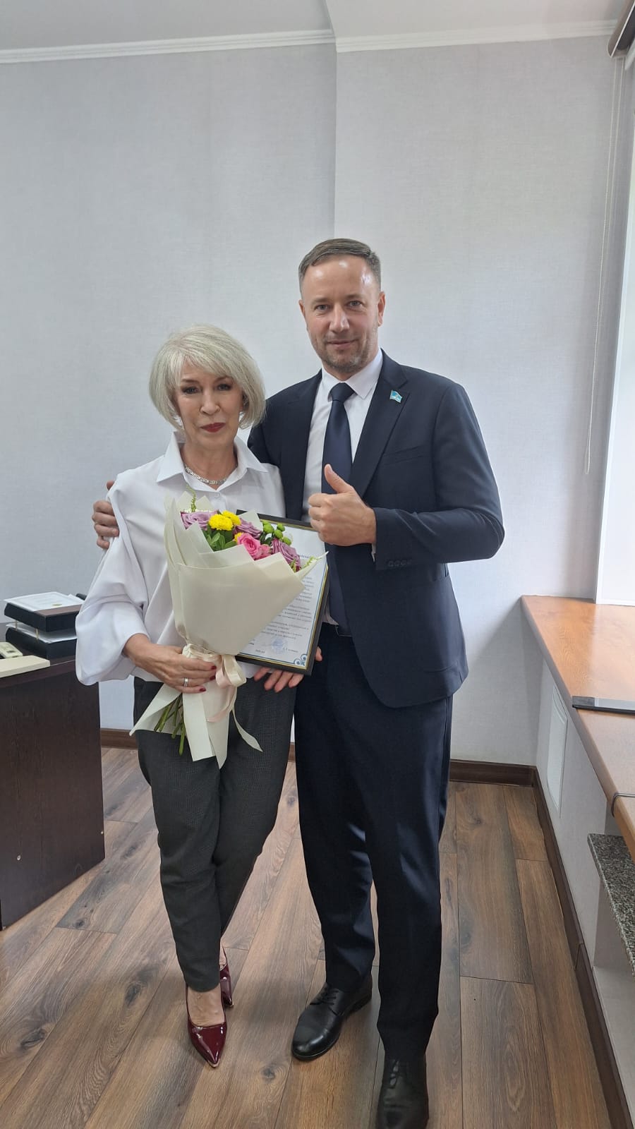 Костюм киген ер адам және гүл шоғы мен сауаттылығы бар әйел