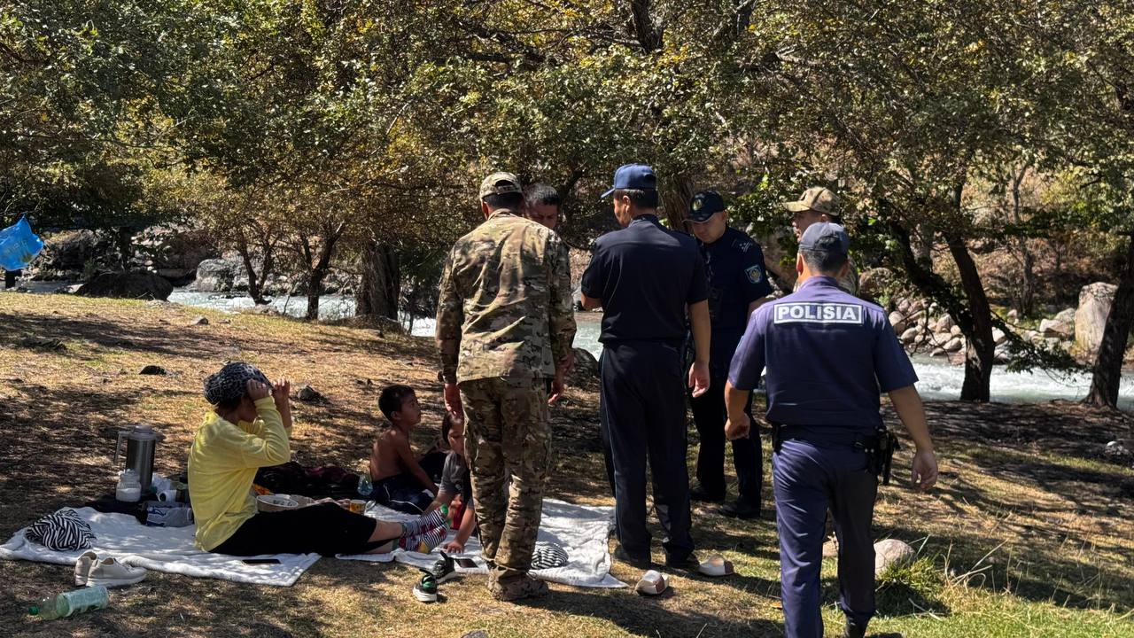 Табиғат аясында демалып жатқан адамдарды тексеріп жатқан полиция және әскери қызметкерлер.