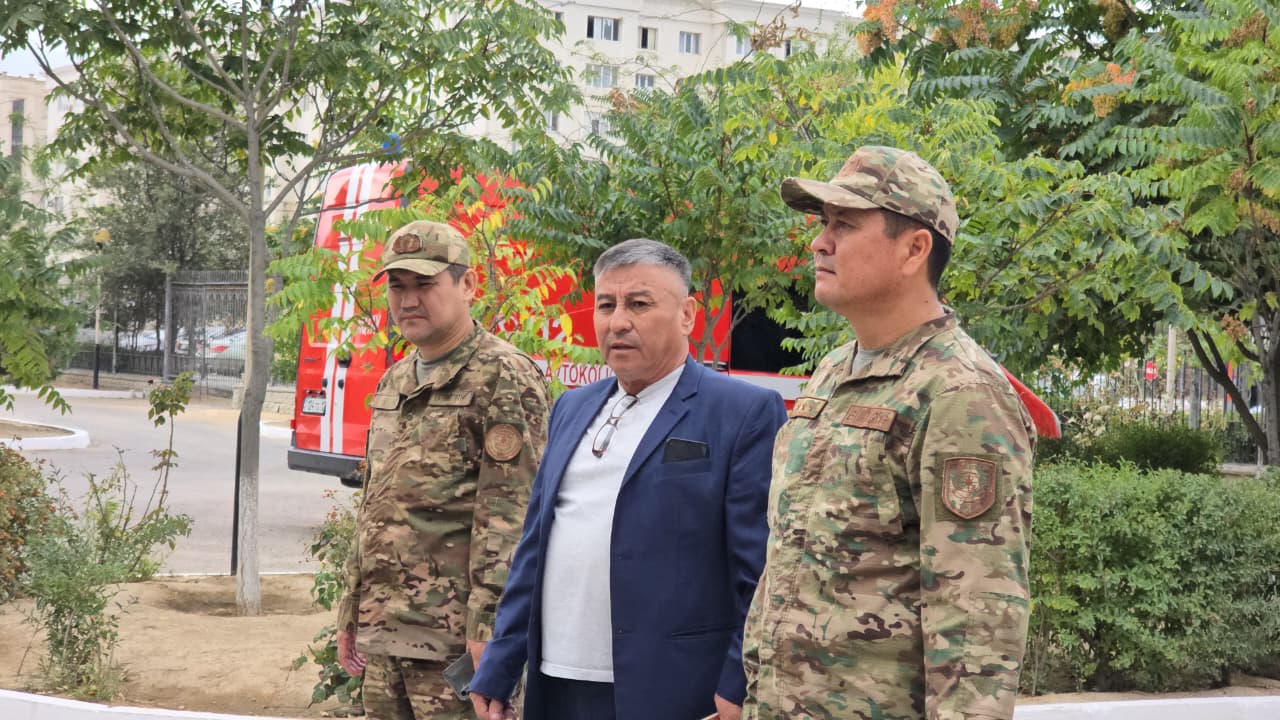 Әскери формадағы екі ер адам мен костюм киген ер адамның сыртқы көрінісі.