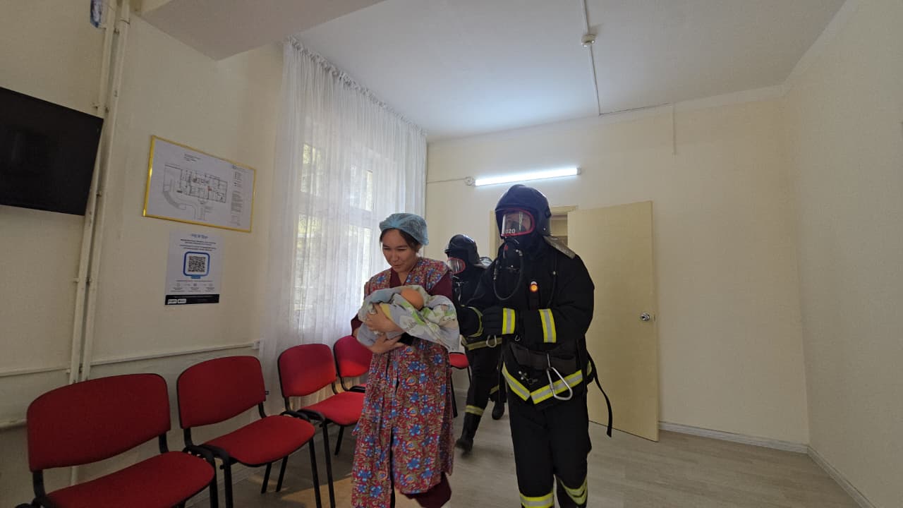 Өрт сөндірушілердің жаңа туған нәрестені құшақтаған әйелді эвакуациялау сәті.