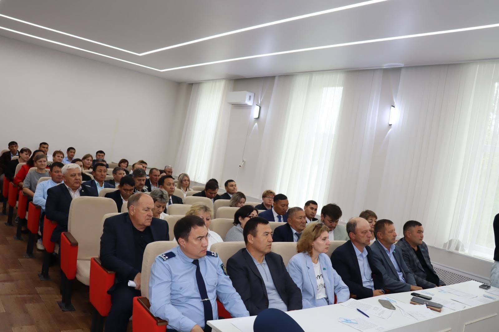 Конференция залында жиналған адамдар тобы.