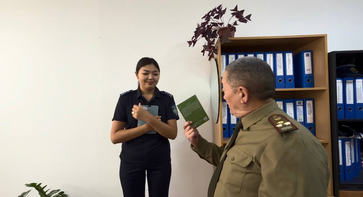 Ветеран вручает книгу сотруднику