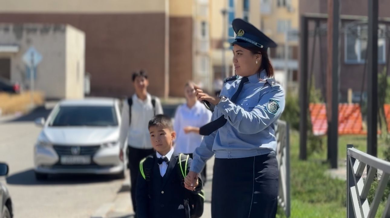 Сотрудница показывает как проходить пешеход школьнику