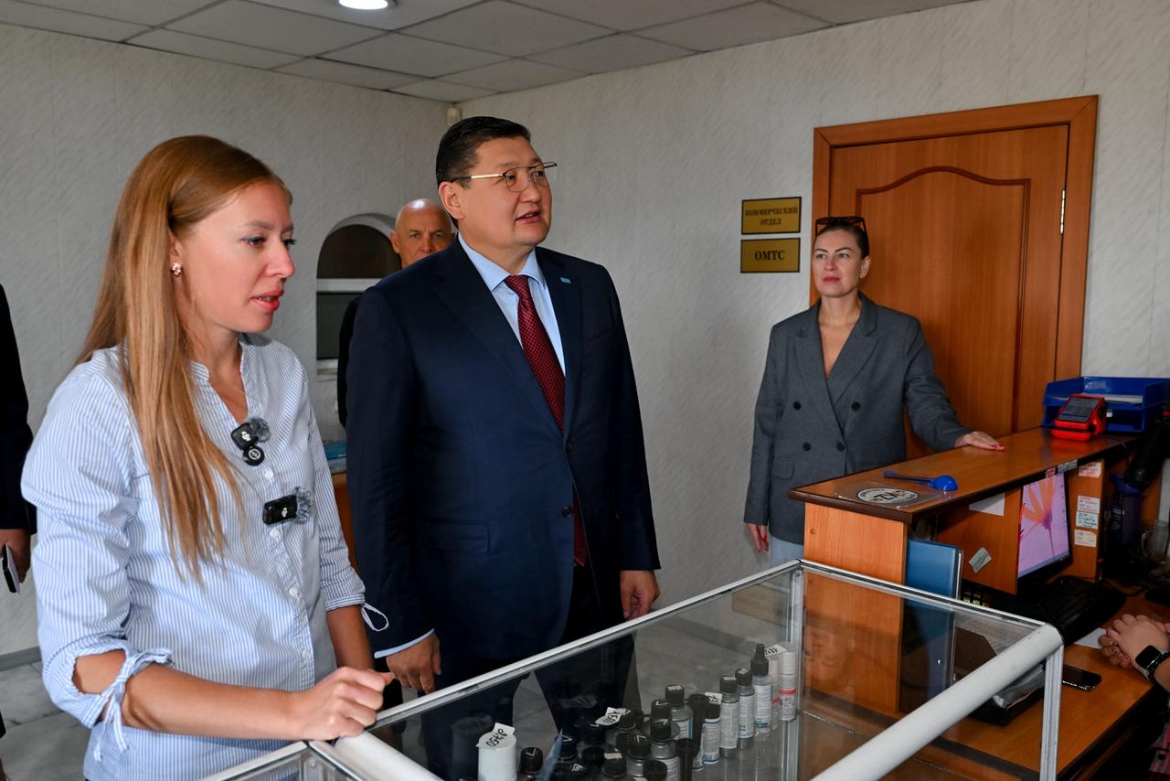 Дәріханадағы витрина алдында тұрған адамдар тобы.