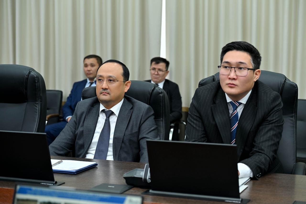 Костюм киген ер адамдар жиналыста ноутбуктердің алдында отыр.
