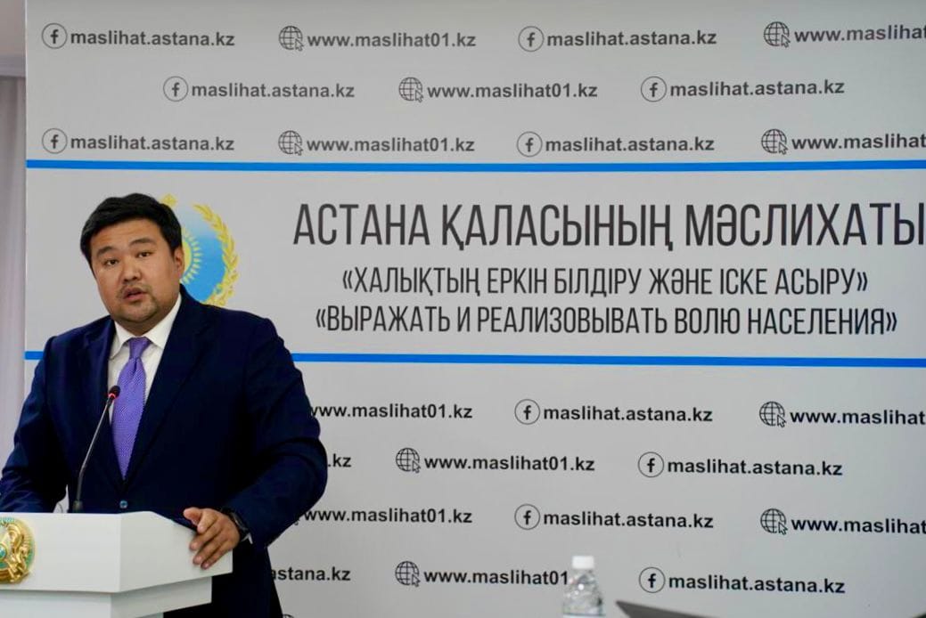 Астана қаласының мәслихатының алдында сөйлеп тұрған ер адам.