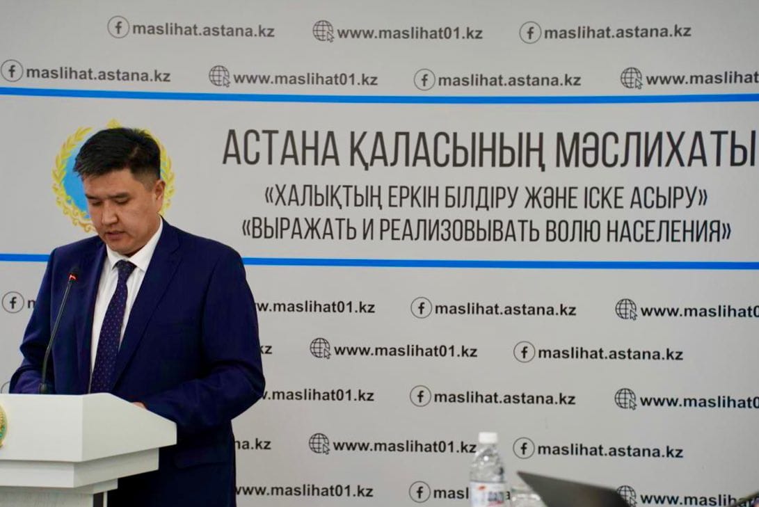 Астана қаласының мәслихатының алдында сөйлеп тұрған ер адам.