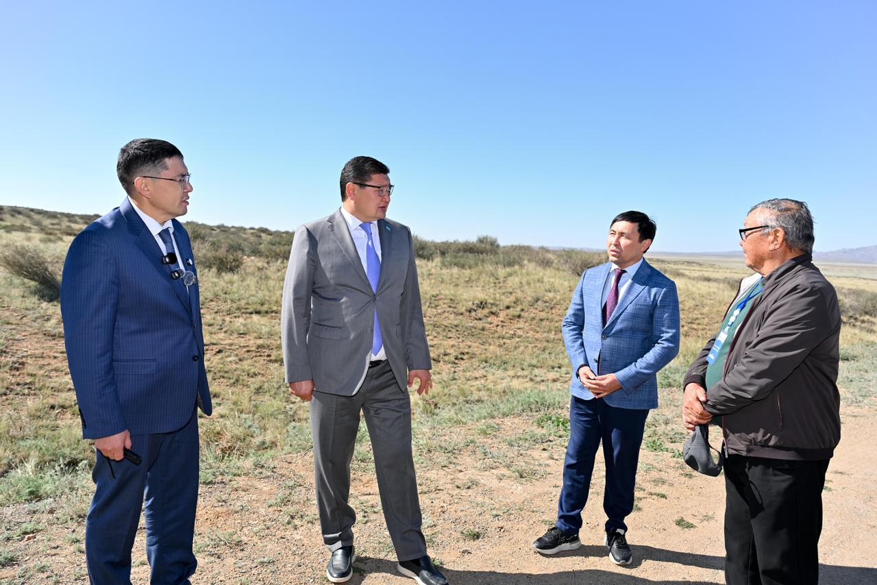 Костюм киген төрт ер адамның ашық жерде тұрып сөйлесіп жатқаны.