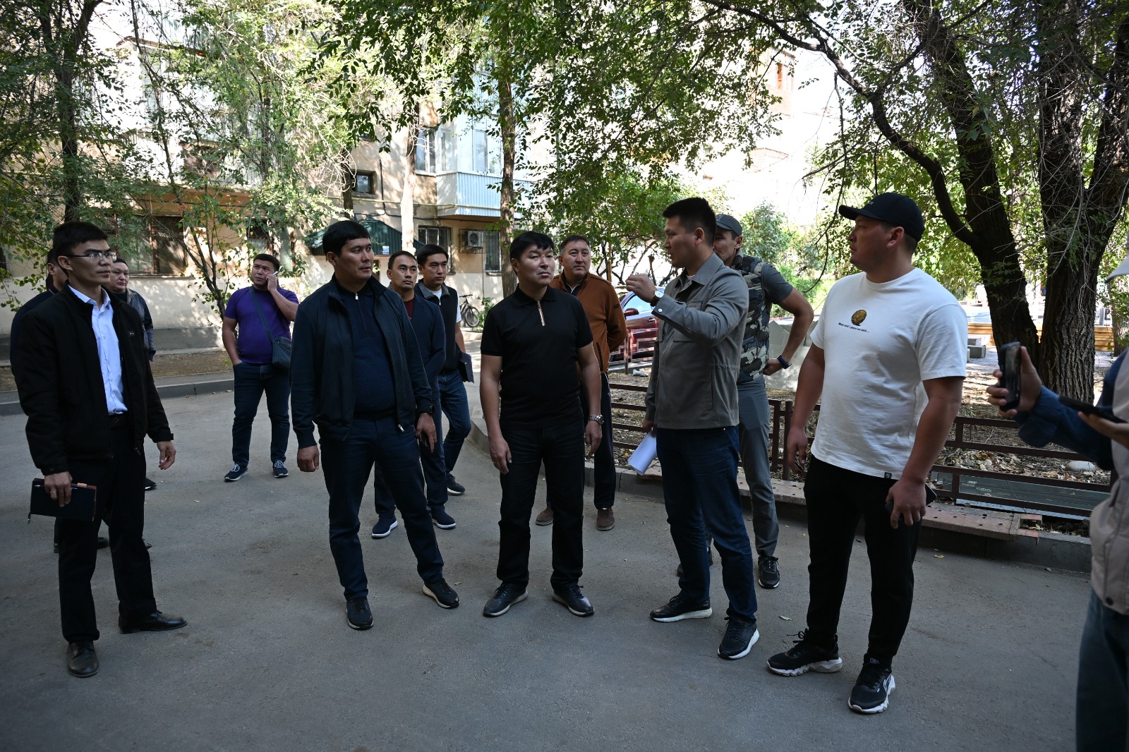 Көшеде жиналып, әңгімелесіп тұрған ерлер тобы.